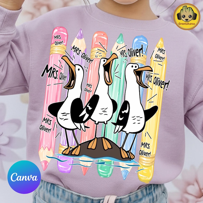 May include: A light purple sweatshirt featuring a graphic print of three seagulls standing on a rock, surrounded by five colorful pencils in pink, purple, orange, green, and yellow. The text "MRS. OLIVER!" is repeated multiple times around the birds.