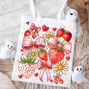 May include: White tote bag with a pink and red strawberry and bow design. The design features strawberries, bows, hearts, and daisies.