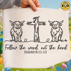 Könnte beinhalten: Cremefarbener Stoff mit einer schwarzen Strichzeichnung von zwei Highland-Rindern, die ein Kreuz flankieren. Der Text "Follow the word, not the herd" und "ISAIAH 8:11-13" steht darunter. Der Stoff wird von einer Person gehalten.