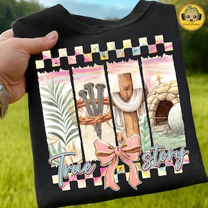 Könnte beinhalten: Schwarzes T-Shirt mit einem farbenfrohen Grafikdesign mit dem Schriftzug "True Story". Das Design umfasst ein Kreuz, Nägel, eine Dornenkrone und eine rosa Schleife. Das T-Shirt hat einen Rundhalsausschnitt und wird von einer Hand gehalten.