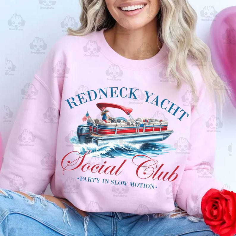 May include: Pink sweatshirt with a graphic of a red, white, and blue pontoon boat with the text "Redneck Yacht Social Club - Party in Slow Motion."