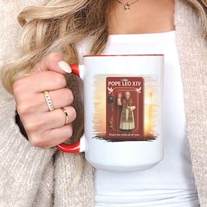 May include: White ceramic mug with a red interior and handle. The mug features an image of Pope Leo XIV with the text "Pope Leo XIV" and "Peace be with all of you." The mug is approximately 15oz.