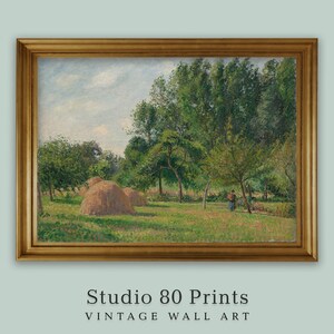 May include: A framed print of a pastoral landscape featuring haystacks in a green field, trees, and a person. The artwork is in a gold frame. The text "Studio 80 Prints VINTAGE WALL ART" is at the bottom.