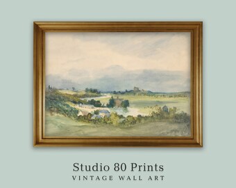 May include: A watercolor painting in a gold frame depicts a landscape with a river winding through a valley.  The scene includes a small village, a castle in the distance, and rolling hills.  The sky is a soft blue with white clouds.