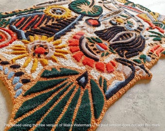 May include: A colorful, abstract rug with a variety of shapes and patterns, including flowers, leaves, and geometric designs. The rug is made of a soft, plush material and has a textured surface.