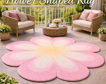 May include: A large, flower-shaped rug with a gradient of colours, from a yellow centre to pink petals. The rug is on a patio with wicker furniture and the text "Flower Shaped Rug".