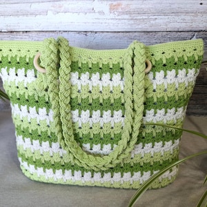 Può includere: Borsa tote all'uncinetto a righe verdi e bianche, con manici ad anello in legno. Le cinghie intrecciate e il design a trama aperta creano un accessorio elegante. Questa borsa fatta a mano è ideale per trasportare oggetti.