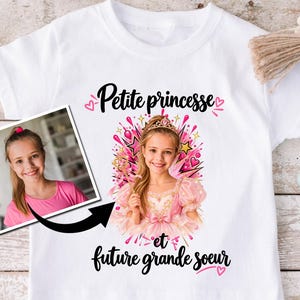 Peut inclure: Un t-shirt blanc à manches courtes avec une impression graphique personnalisée d'une jeune fille déguisée en princesse avec un diadème, entourée d'étoiles et de cœurs roses. Le texte indique "Petite princesse et future grande soeur".
