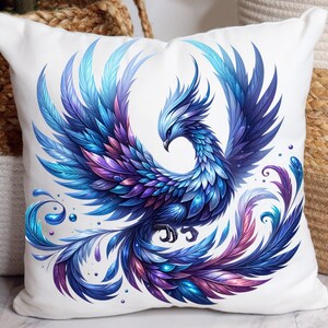 Könnte beinhalten: Weißes quadratisches Kissen mit einem lebendigen Phönix-Design. Der Phönix ist mit blauen, lila und türkisfarbenen Federn dargestellt, mit einer detaillierten Illustration der Form des Vogels. Das Kissen ist ein dekoratives Wohnaccessoire.