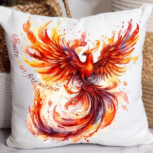 May include: White throw pillow with a watercolor painting of a phoenix with orange, red, and yellow feathers. The text "Ignite your fire within" is written on the pillow.