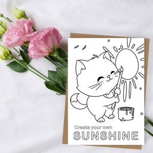 May include: Black and white coloring page featuring a cute cat painting a sun with a paintbrush. The text "Create your own SUNSHINE" is at the bottom of the page.