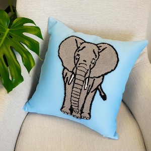 a blue pillow with a picture of an elephant on it