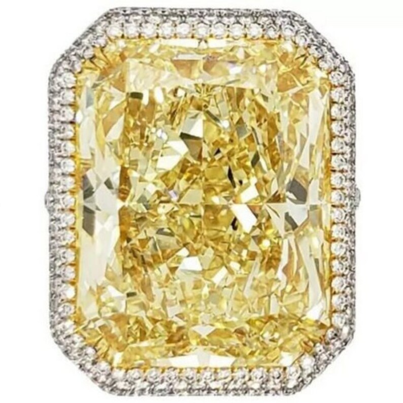 May include: A large, radiant cut, canary yellow diamond ring with a diamond halo setting.