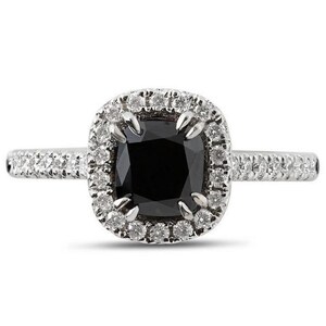 Può includere: Un anello d'argento con una grande pietra nera a taglio quadrato al centro, circondata da un alone di pietre più piccole e trasparenti. Anche il gambo dell'anello è incastonato con piccole pietre trasparenti, creando un effetto scintillante.