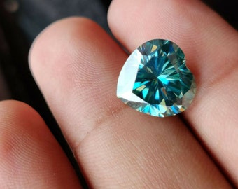 May include: A heart-shaped blue moissanite gemstone with a brilliant cut and a faceted design.