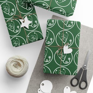 May include: Gift-wrapped presents with green paper featuring a white stethoscope pattern. Each package is tied with twine and a white tag. A spool of twine, scissors, and blank tags are also visible.