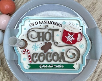 May include: A grey ceramic mug with a white and red design that says "Old Fashioned Hot Cocoa" with a green banner that says "Open all winter".