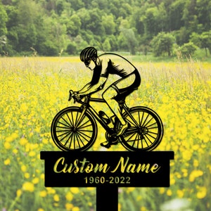 Puede incluir: Silueta negra de un ciclista montando una bicicleta en un campo de flores amarillas. El letrero de abajo dice "Custom Name 1960-2022".