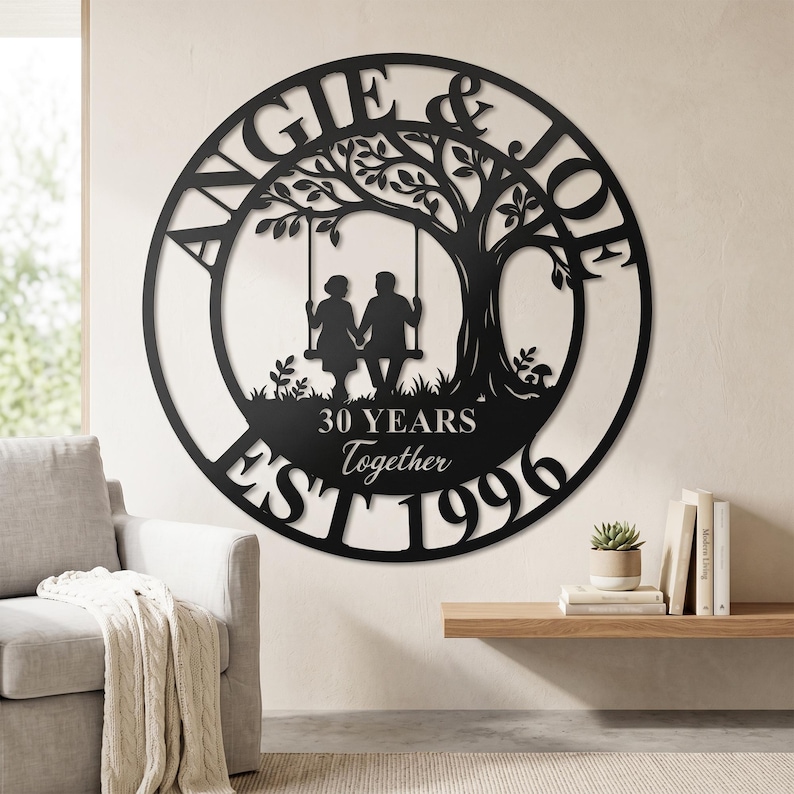 Puede incluir: Un letrero de pared circular de metal negro con la silueta de una pareja en un columpio bajo un &aacute;rbol. El texto dice ANGIE & JOE, 30 YEARS Together y EST 1996. El dise&ntilde;o est&aacute; cortado de una sola pieza de metal con un acabado negro mate.