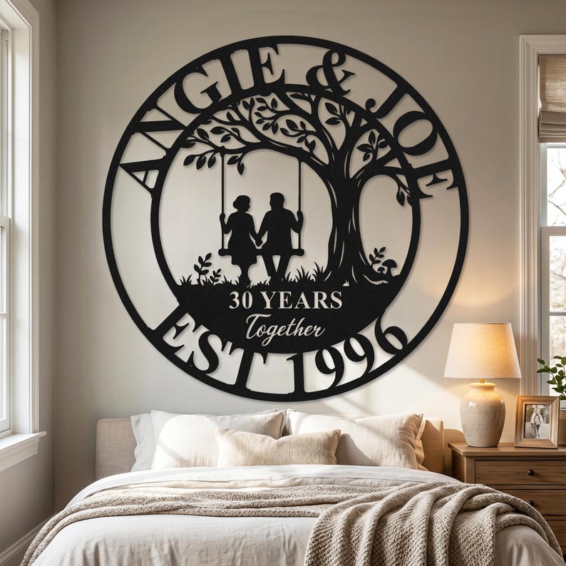Puede incluir: Un letrero de pared circular de metal negro con la silueta de dos personas sentadas en un columpio bajo un &aacute;rbol. El texto dice ANGIE & JOE, 30 YEARS Together y EST 1996. El dise&ntilde;o est&aacute; recortado en una sola pieza de metal con acabado mate.