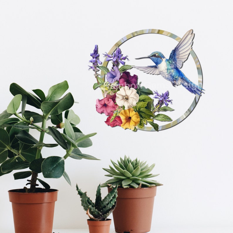 May include: A blue hummingbird with a long beak flies through a circle with a floral design. The flowers are pink, purple, yellow, and white.