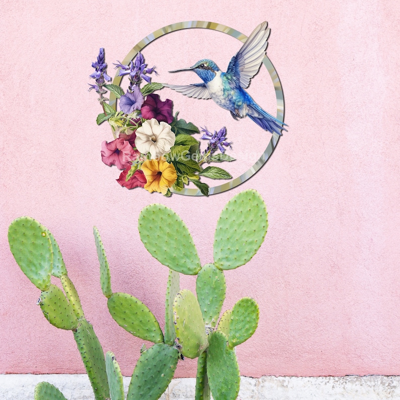 May include: A blue hummingbird with a long beak flies in a circle with a floral arrangement of purple, pink, white, and yellow flowers. The circle is on a pink wall with a green cactus plant in the foreground.