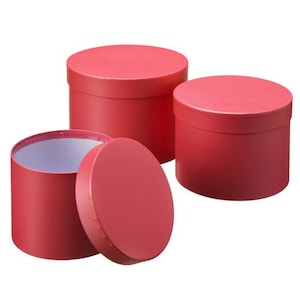 May include: Three round, red cardboard boxes of varying sizes. The boxes are empty and have a smooth, matte finish.
