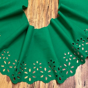 Puede incluir: Borde de tela verde con un borde festoneado y un diseño de corte floral.