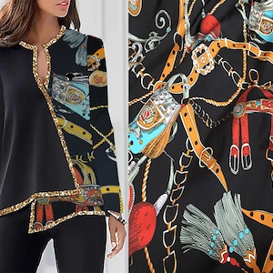 May include: Black long-sleeve shirt with a gold trim and a colorful pattern of chains and tassels on the right side of the shirt.
