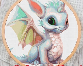 May include: A light blue baby dragon with a pink ear and green eyes sits on a white background. The dragon has a white horn on its head and a light pink and green wing.