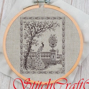 May include: A black and white cross-stitch pattern of a peacock standing in a garden with a tree and a vase of flowers. The pattern is framed in a wooden hoop.