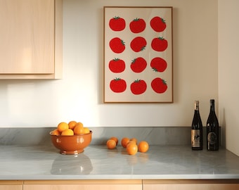 May include: A kitchen scene featuring a framed print with red tomato illustrations. A terracotta bowl filled with oranges sits on a gray countertop, with additional oranges scattered nearby. Two wine bottles are also on the counter.