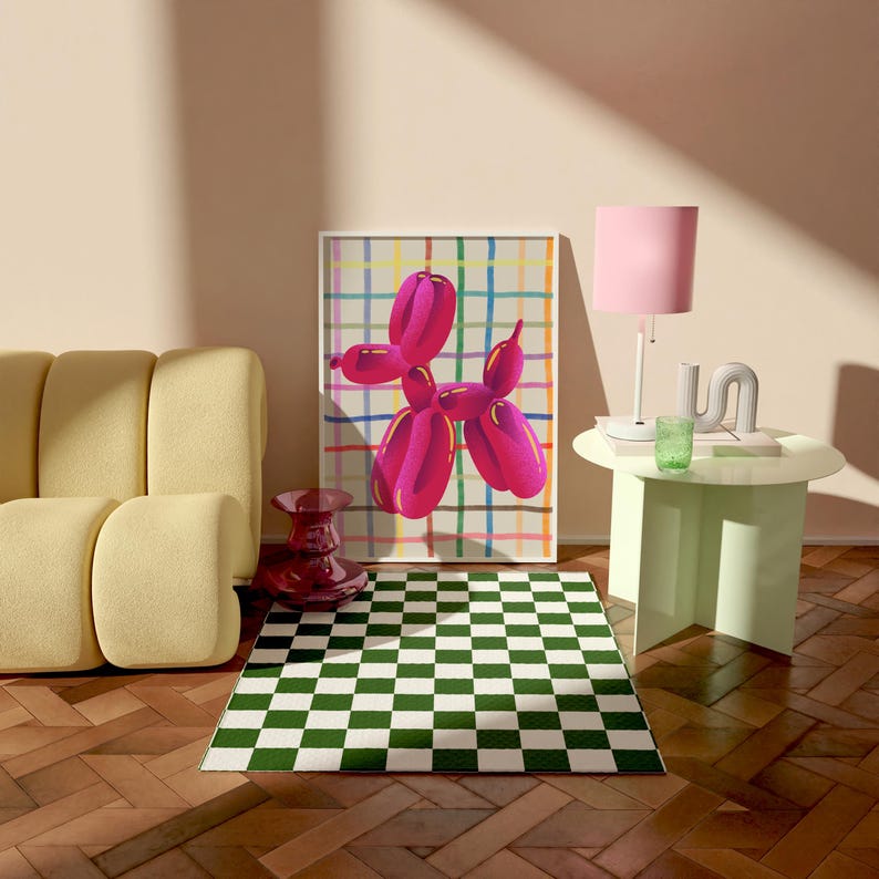 May include: A modern living room scene featuring a framed artwork of a pink balloon dog against a colorful grid background. A green and white checkered rug sits on a wooden floor. A yellow sofa, a pink lamp, and a small table complete the decor.