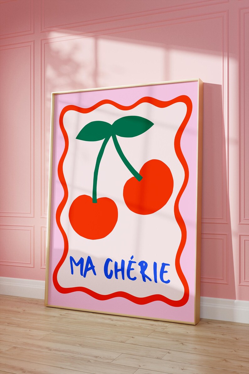 May include: A pink and white poster with a red border features a pair of red cherries with green stems and leaves. The text "MA CH&Eacute;RIE" is written in blue letters at the bottom of the poster.