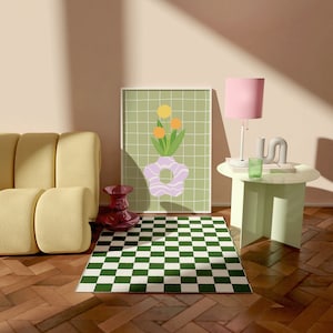 May include: A room scene with a yellow sofa, a green and white checkered rug, and a framed art print with a floral design. A pink lamp and a small side table with a green glass and decorative object are also present. A red vase is on the floor.