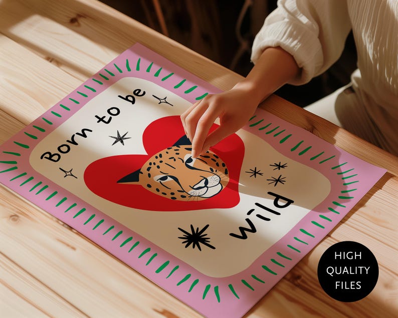 May include: A rectangular print featuring a cream-coloured centre with a red heart and a cheetah face illustration. The text "Born to be wild" is printed in black. The border is light pink with green dashes and black star accents.