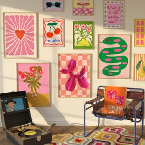 May include: A selection of framed art prints with a retro theme, featuring a pink heart, cherries, a balloon dog, and a green snake. A vintage record player and a chair with a "Feeling Lucky" cushion complete the room's decor.