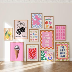 May include: A gallery wall collection of eleven framed art prints featuring diverse illustrations including lemons, dice with the text feeling lucky, a balloon dog, fruit market text, mugs, cool people live here text, gummy bears, a disco ball ice cream, Matisse style shapes, flowers, and this is my happy place text.