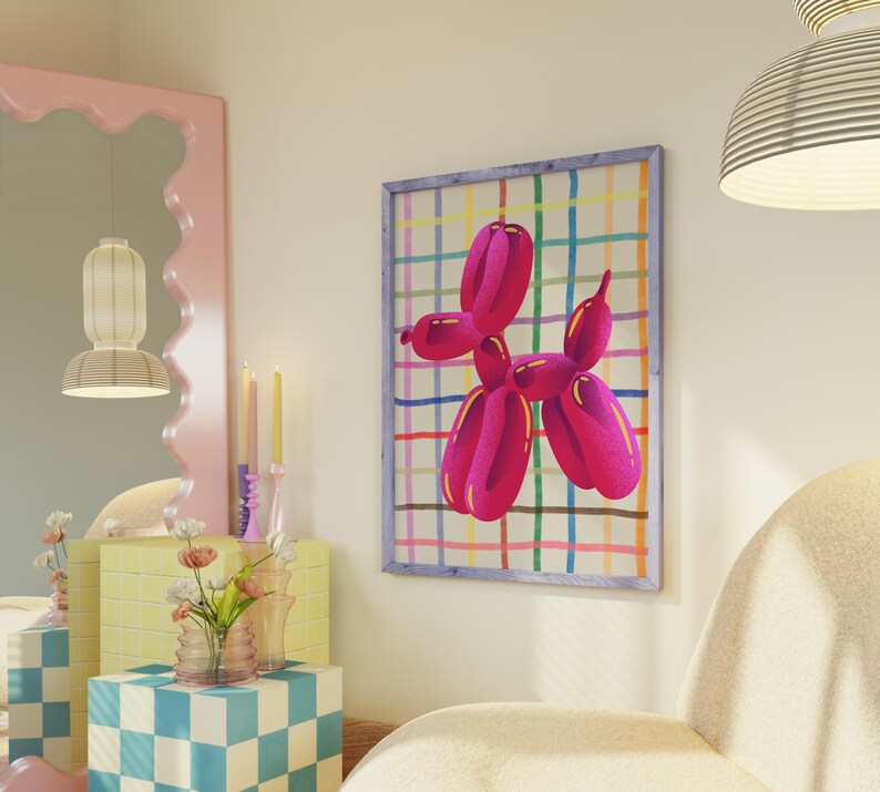 May include: A framed artwork featuring a vibrant pink balloon dog against a colorful plaid background. The artwork is displayed on a cream-colored wall, adding a pop of color to the room. The artwork is framed in a light blue frame.