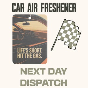 May include: Car air freshener with a rectangular design featuring a car interior illustration and the text "LIFE'S SHORT. HIT THE GAS." A checkered flag graphic is also present.