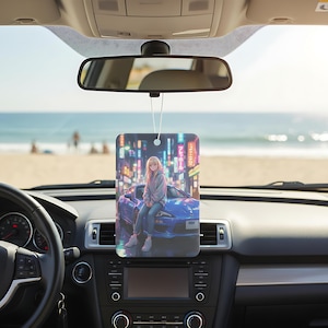 May include: Rectangular car air freshener featuring an anime-style illustration of a person sitting on a blue sports car in front of a cityscape with neon signs. The air freshener hangs from a string.