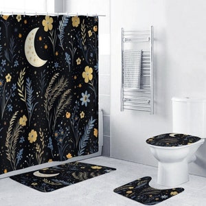 Op de afbeelding: Een zwarte douchegordijn met een bloemen- en maanpatroon. Het gordijn wordt geleverd met een bijpassende badmat en toiletbrilhoes. De badkamer heeft ook een handdoekrek.