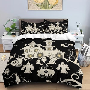 May include: Black and white Halloween bedding set with a spooky house, ghosts, and a cauldron. The bedding features a repeating pattern of these elements on a black background.