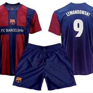 Puede incluir: Una camiseta de fútbol azul y roja con el logotipo del FC Barcelona y el nombre "LEWANDOWSKI" y el número "9" en la espalda. Un pantalón corto de fútbol azul con el logotipo del FC Barcelona.