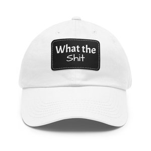 Könnte beinhalten: Weiße Baseballkappe mit einem schwarzen Patch, auf dem in weiß "What the Shit" steht.