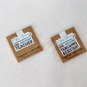 May include: Two magnetic bookmarks in clear packaging. Each bookmark has a brown background with the text "Mrs. Jones" and "ONE AWESOME TEACHER" or "ONE AWESOME TEACHING ASSISTANT". The bottom of the bookmark reads "Magnetic bookmark obliquekrafts.etsy.com".