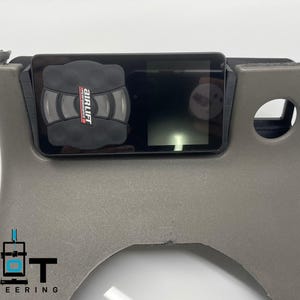 May include: A gray plastic panel with a black air suspension control unit mounted to it. The control unit has a digital display and a button with the text "AirLift Performance" on it.