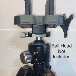 May include: A black tripod with a gray and black phone mount attached. The phone mount has a quick release plate and a side-mounted lever. The tripod has a ball head, but the ball head is not included.  Ball Head Not Included.