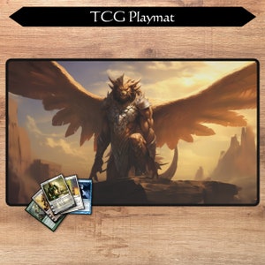 May include: A TCG playmat featuring a golden-brown winged creature with a lion-like head, standing on a rocky outcrop against a sunset background. The playmat has a textured surface and is designed for use with trading card games.