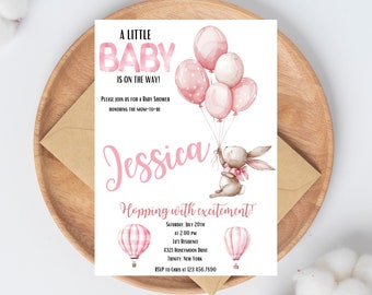 Pode incluir: Convite para chá de bebé com texto e ilustrações cor-de-rosa. O convite diz "A Little Baby Is On The Way!" e inclui o nome "Jessica". Um coelhinho segura balões. O convite está sobre um prato de madeira.
